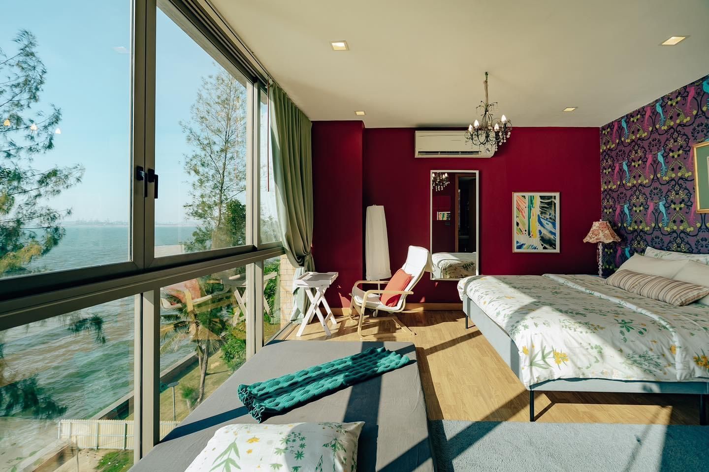 Bright bedroom at Pink Sand Beachfront Villa, บางละมุง พัทยาเหนือ, with ocean view, daybed, and floral bedding.