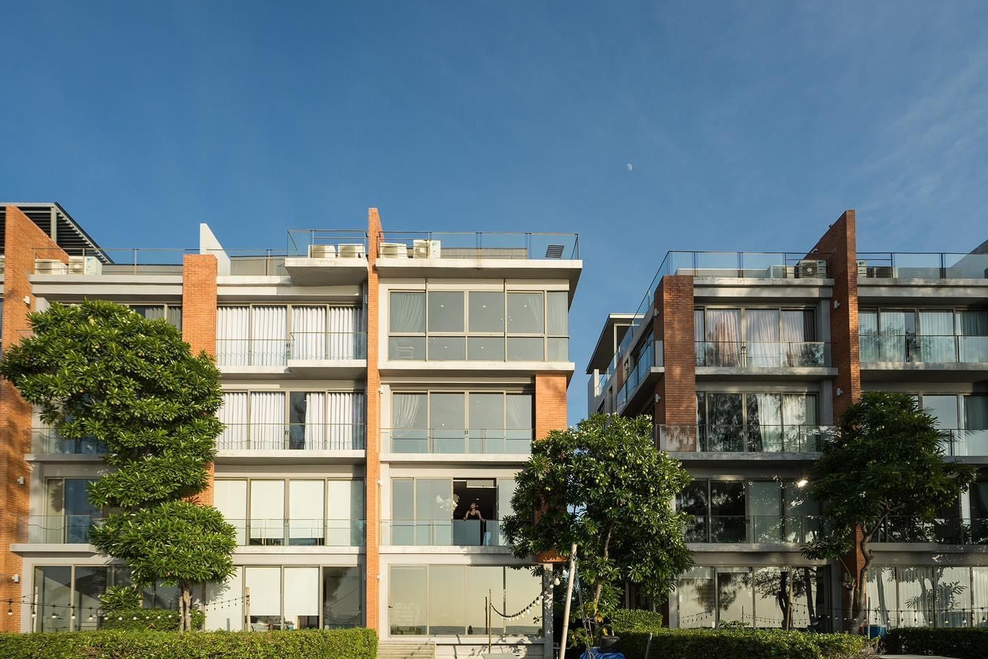 Pink Sand Beachfront Villa exterior in บางละมุง, พัทยาเหนือ. Modern building with brick facade and large windows.