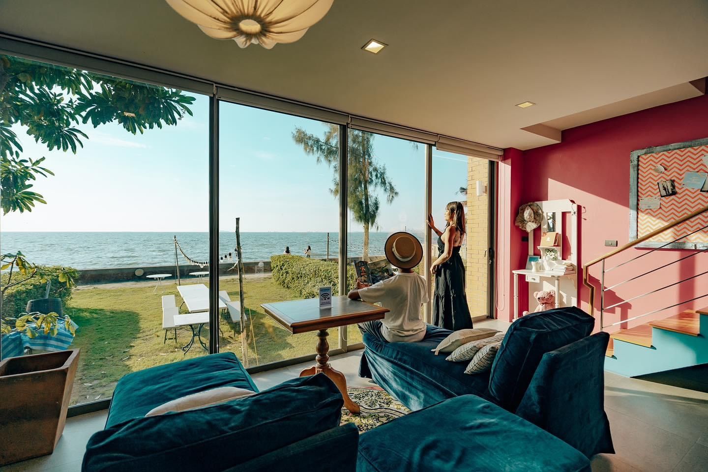 Ocean view from the living room at Pink Sand Beachfront Villa, บางละมุง พัทยาเหนือ. People enjoy the view from the sofa.