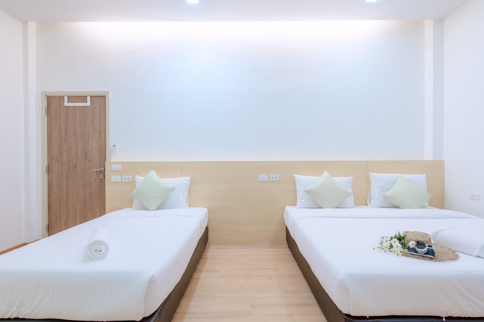 Bright bedroom with twin beds at Pool Lay AII Pool Villa, Na Jomtien, Pattaya. Features decor with hat, camera, and flowers.