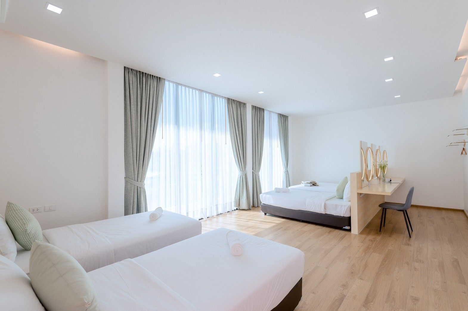 Bright bedroom with three beds at Pool Lay AII Pool Villa, Na Jomtien, Pattaya. Modern design, light wood floors, sheer curta