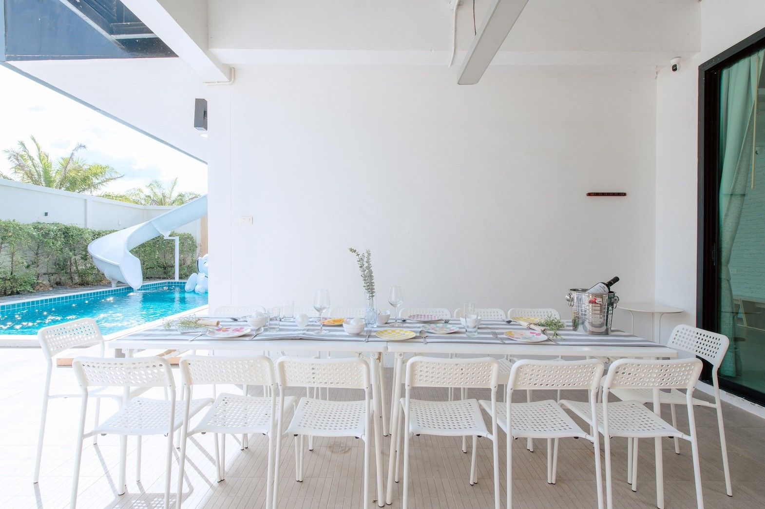 Poolside dining table at Pool Lay AII Pool Villa, Na Jomtien, Pattaya. Seats 10, overlooks pool with slide.