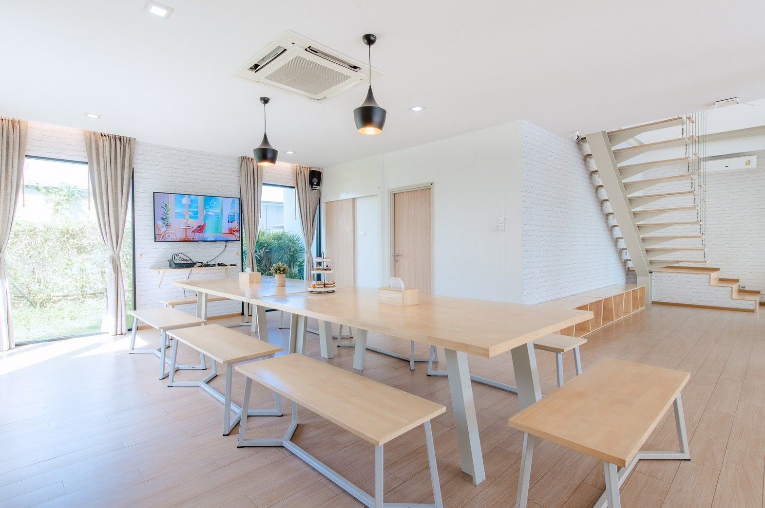 Bright dining area with large wooden table and benches at Pool Lay AII Pool Villa, Na Jomtien, Pattaya.