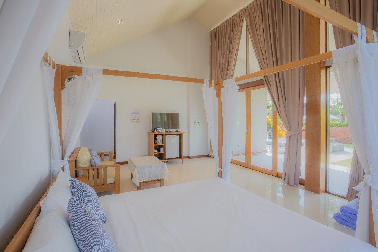 Bright bedroom with four-poster bed at Proud I Pool Villa, Hua Hin, Thailand.