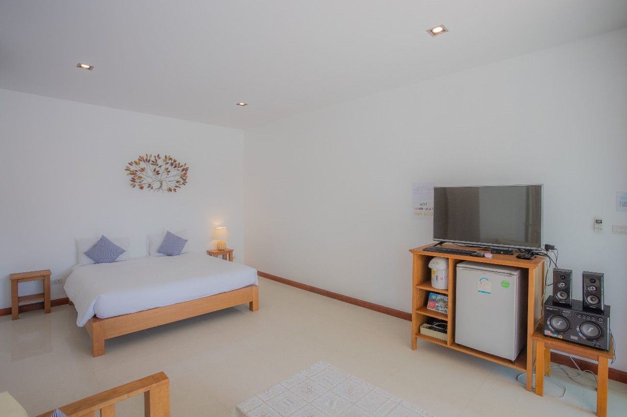 Bright bedroom with TV and mini fridge at Proud I Pool Villa, Hua Hin, Thailand.