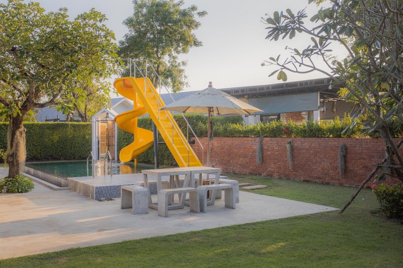 Fun poolside slide and seating area at Proud I Pool Villa, Hua Hin, Thailand.