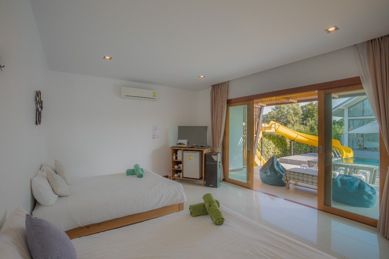 Bright bedroom with pool view and waterslide at Proud II Pool Villa, Hua Hin, Thailand.
