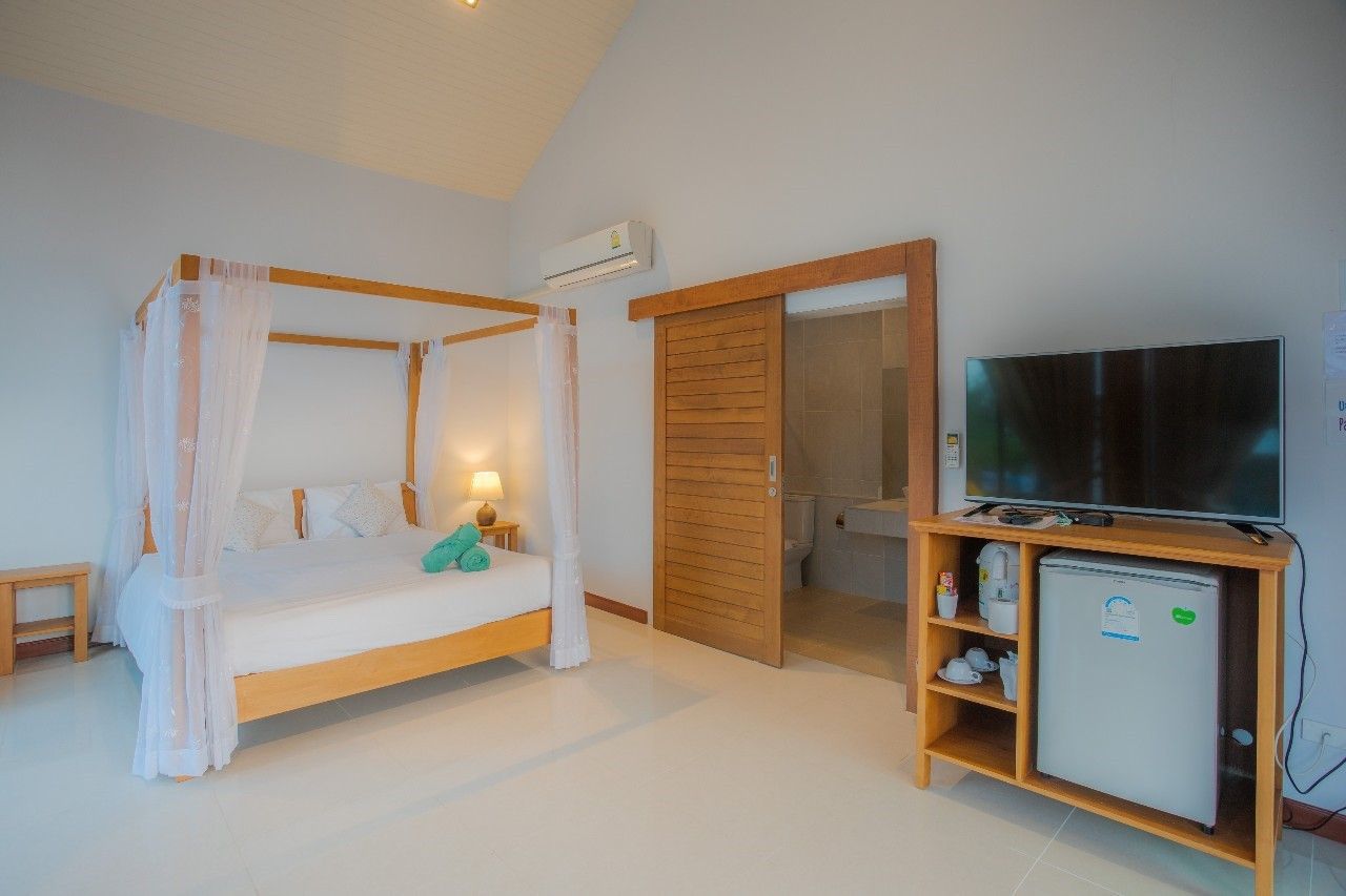 Bedroom with four-poster bed and ensuite bathroom at Proud II Pool Villa, Hua Hin, Thailand.