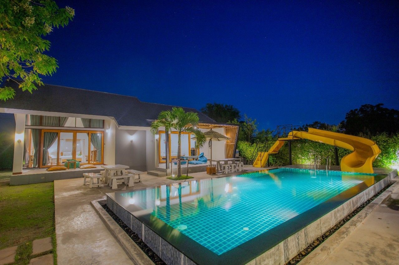 Night view of the pool and slide at Proud II Pool Villa, Hua Hin. Perfect for a family vacation.