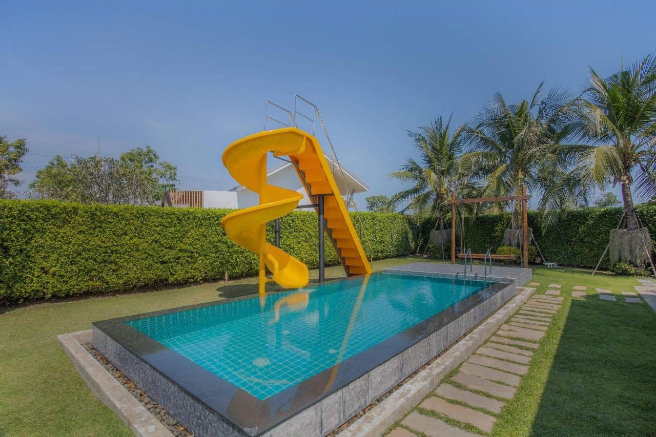Bright yellow water slide into the pool at Proud III Pool Villa, Hua Hin. Fun for the whole family!