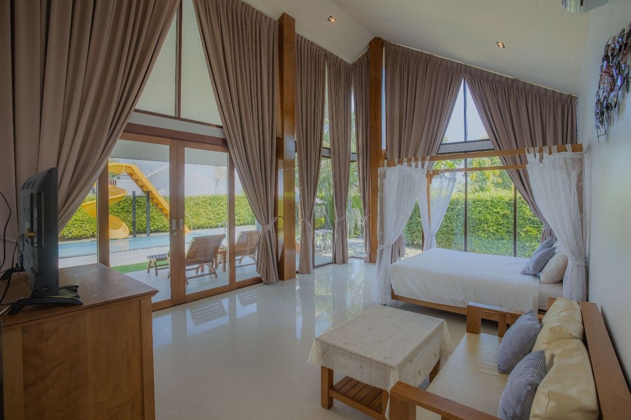 Bright bedroom with four-poster bed and pool view at Proud III Pool Villa, Hua Hin, Thailand.