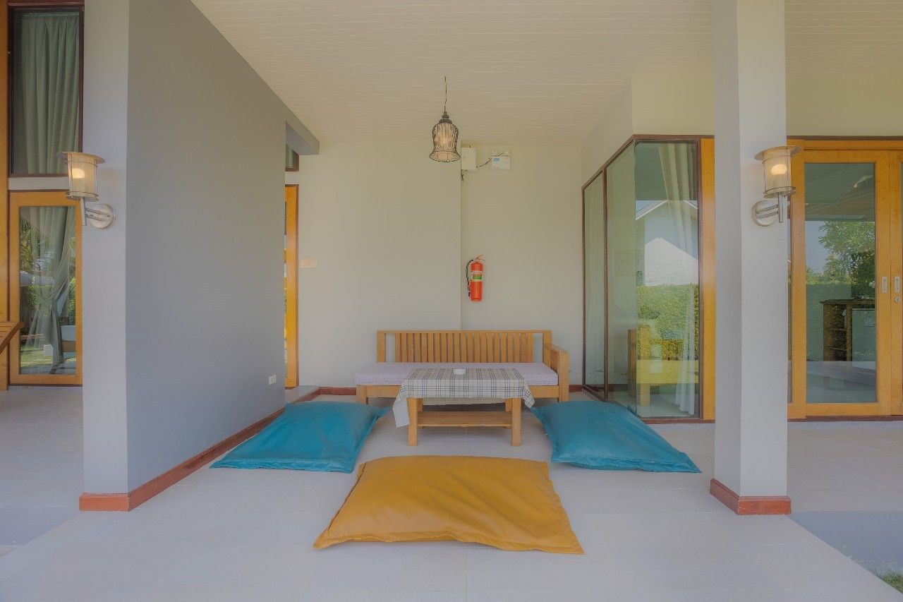 Relaxing covered patio with floor cushions at Proud III Pool Villa, Hua Hin. Enjoy outdoor lounging.