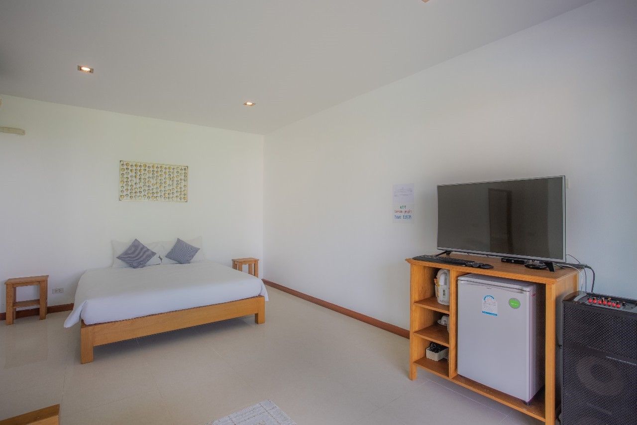 Bright bedroom with TV and mini fridge at Proud III Pool Villa, Hua Hin, Thailand.