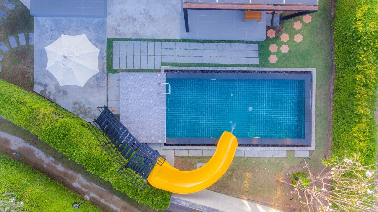 Aerial view of the pool and slide at Proud IV Pool Villa, Hua Hin. Perfect for family fun in Thailand.
