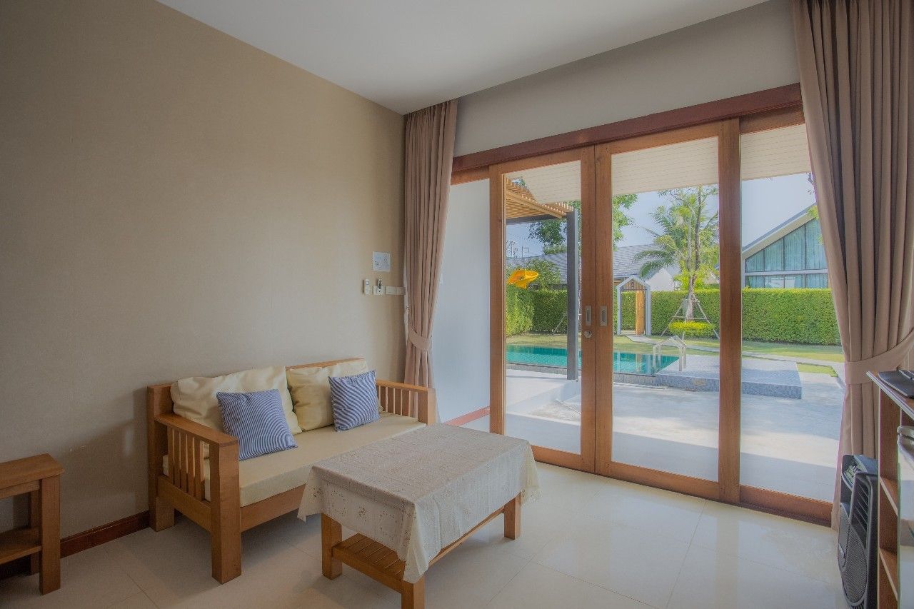 Cozy sofa seating area with pool view at Proud V Pool Villa, Hua Hin. Relax in style.