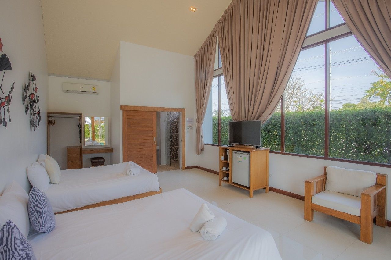 Bright bedroom with twin beds and large window at Proud V Pool Villa, Hua Hin, Thailand.