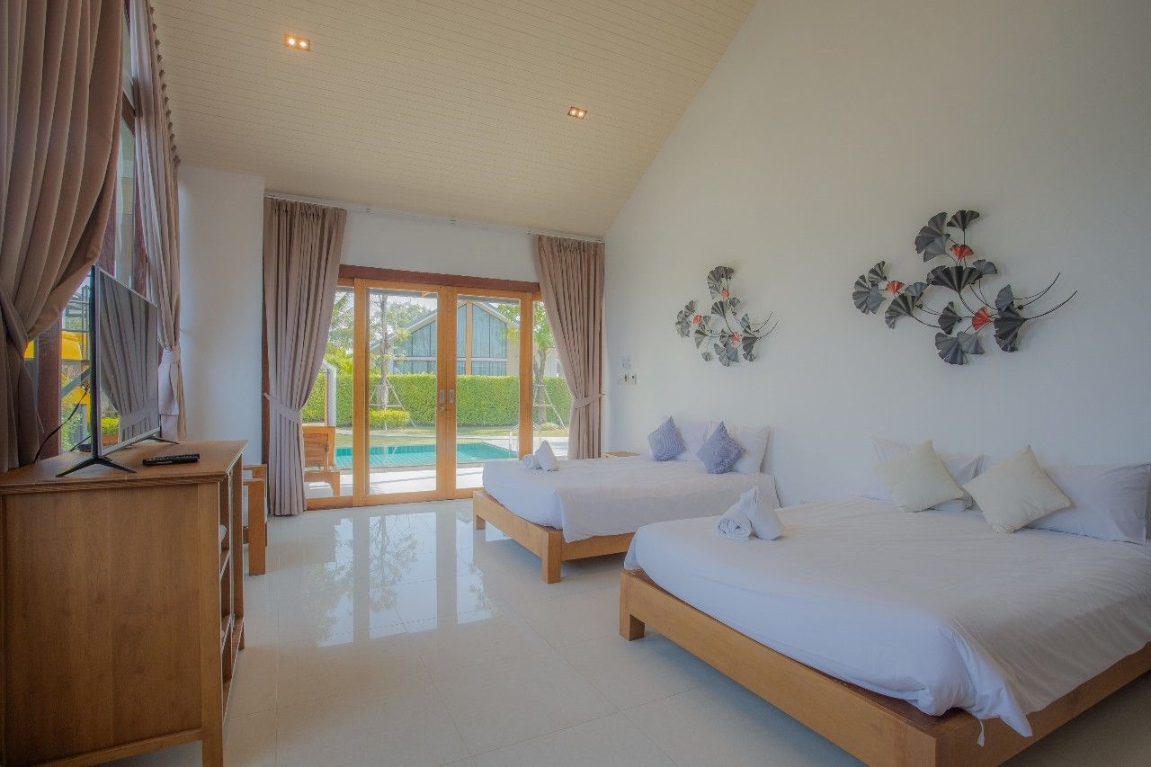 Bright bedroom with pool view at Proud V Pool Villa, Hua Hin. Two beds, white linens, and modern decor.