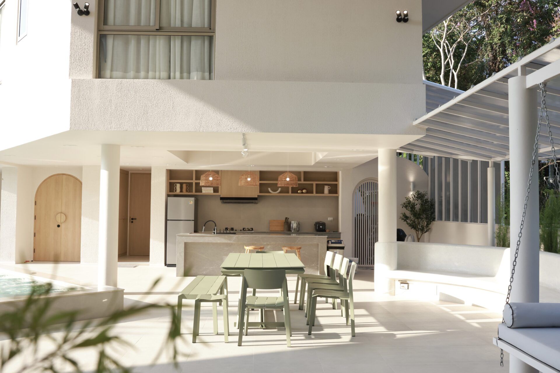 Outdoor dining area and kitchen at Roove V Pool Villa near Khaoyai National Park. Modern table and chairs.
