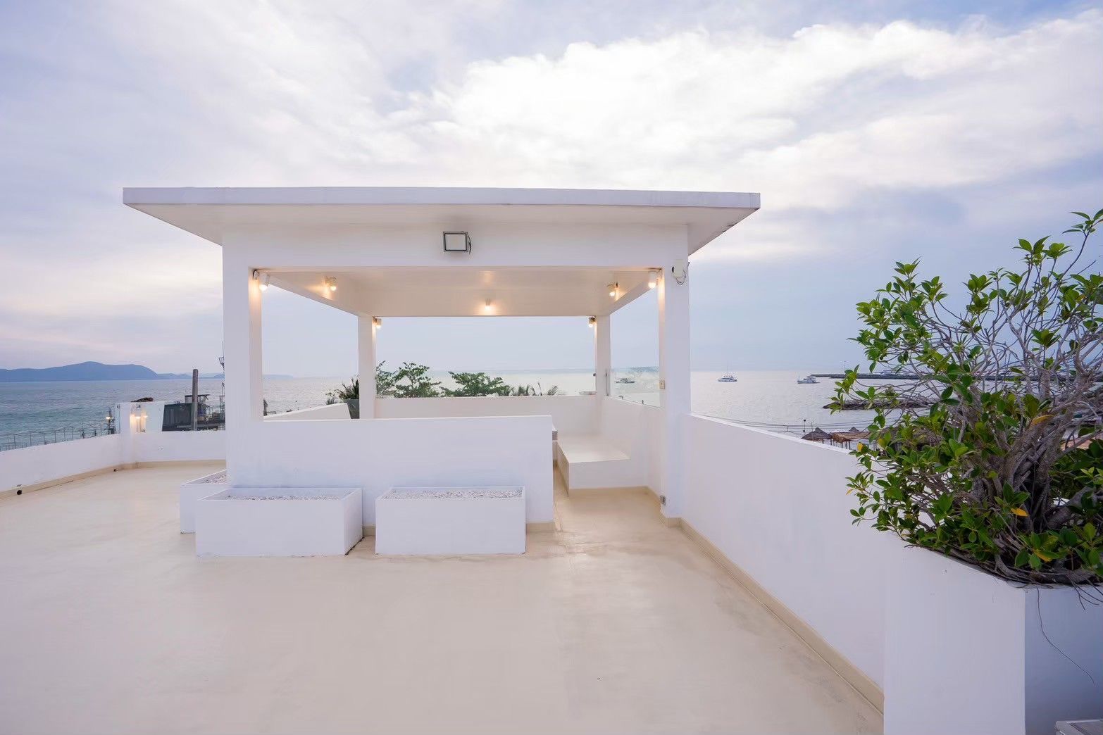 Rooftop terrace with ocean view at Royal Beach X Pool Villa, ติดทะเลนาจอมเทียน พัทยาใต้. White gazebo and planters.