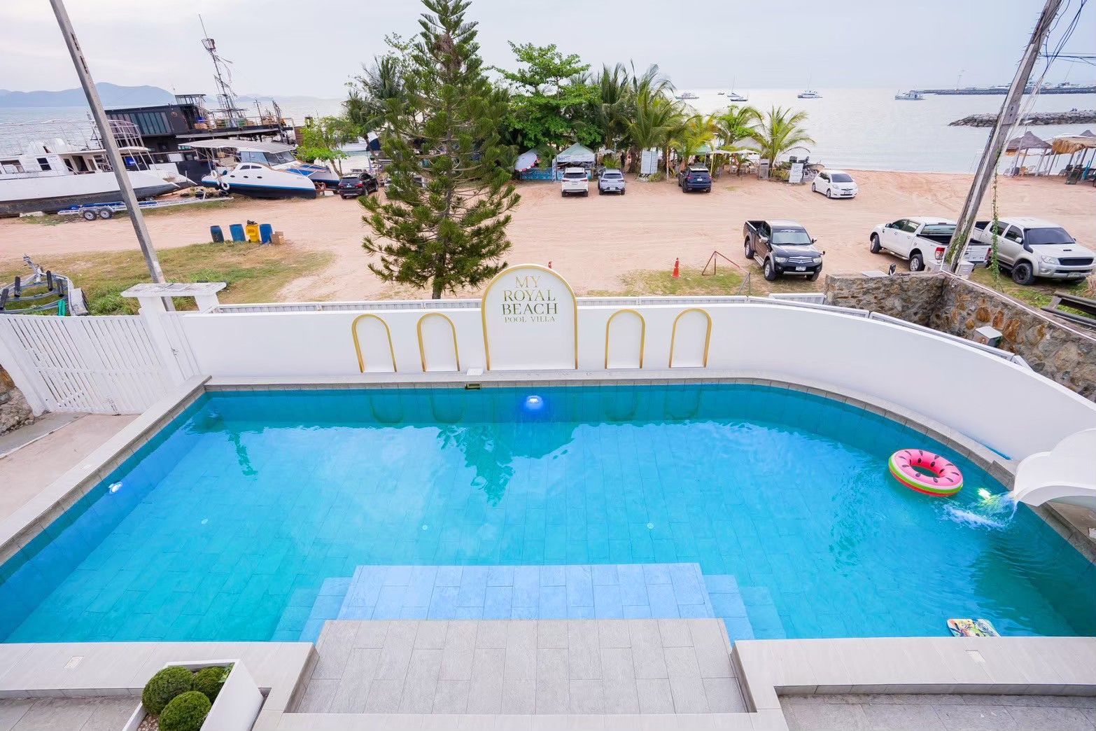 Royal Beach X Pool Villa beachfront pool view in Pattaya. See the beach and boats from the pool.