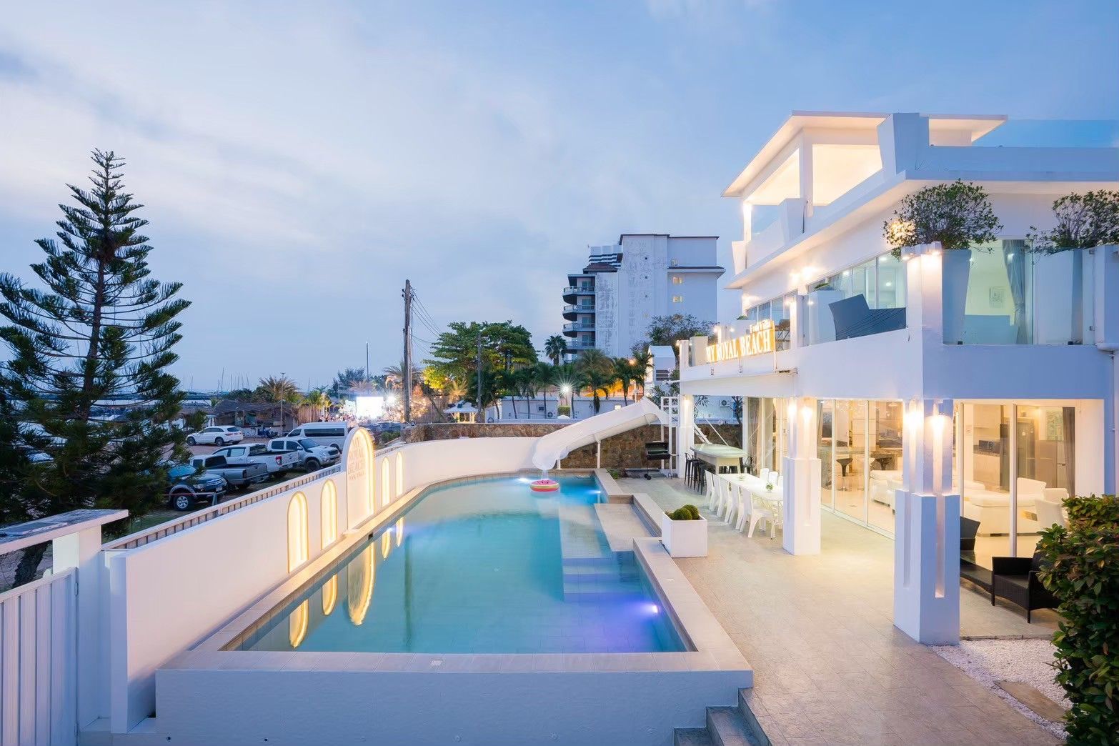 Royal Beach X Pool Villa pool with water slide, Pattaya. View of the villa and pool at dusk.