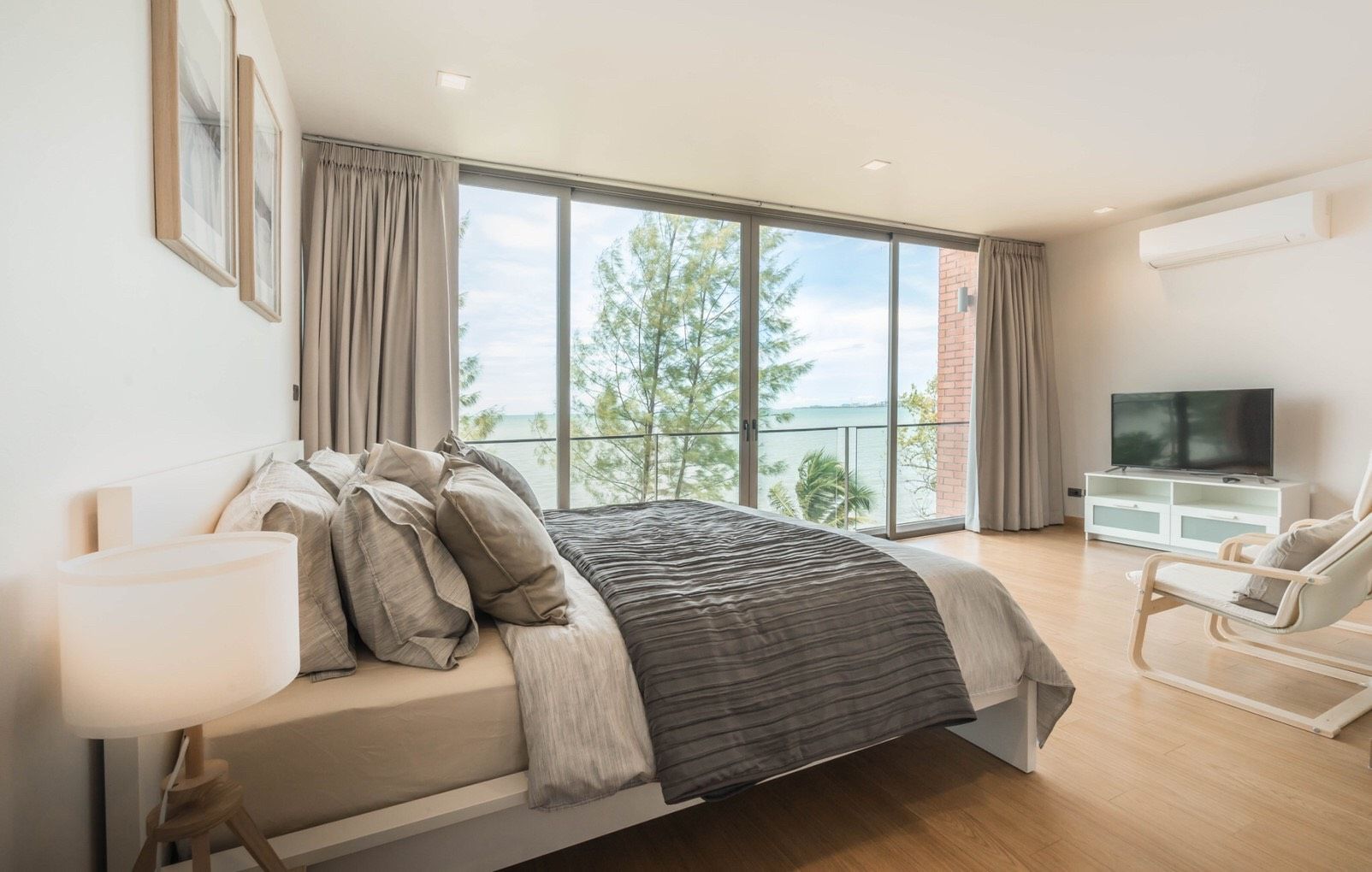 Bedroom with ocean view at Sand Beachfront Exclusive Villa, North Pattaya. King bed, TV, and large windows.