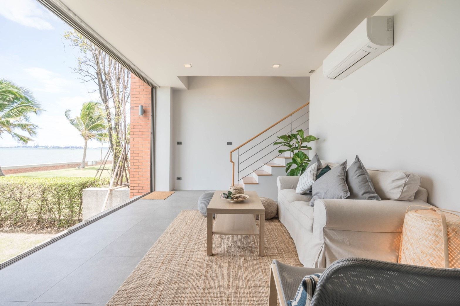 Bright living room with ocean view at Sand Beachfront Exclusive Villa, ติดทะเลพัทยาเหนือ บางละมุง. Coastal decor, sofa, stair