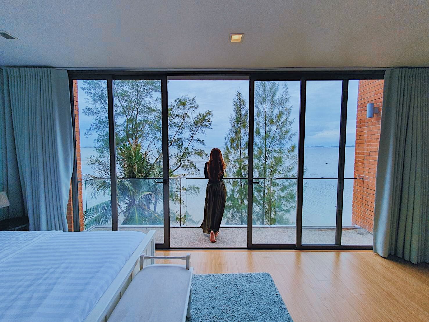 Ocean view from the bedroom balcony at Sand Beachfront Pool Villa III, ติดทะเลพัทยาเหนือ บางละมุง. Woman enjoying the view.