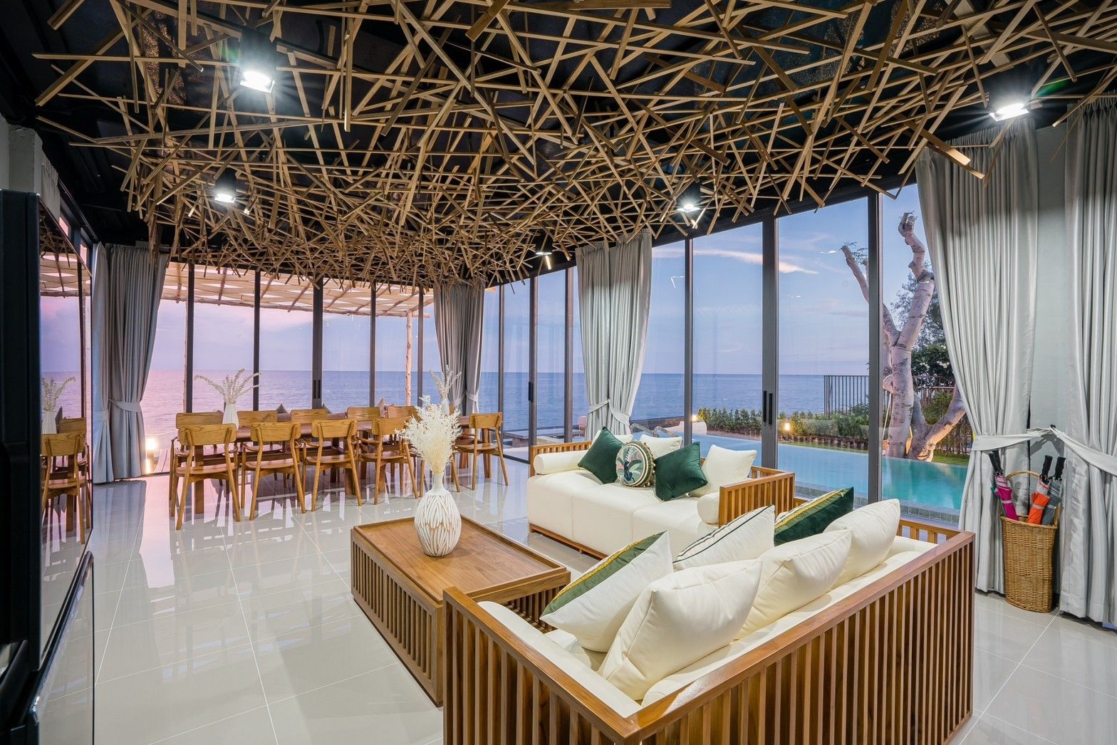 Living area with ocean view at Sea Fan IV Beachfront Pool Villa near Huahin airport. Modern sofas and dining table.