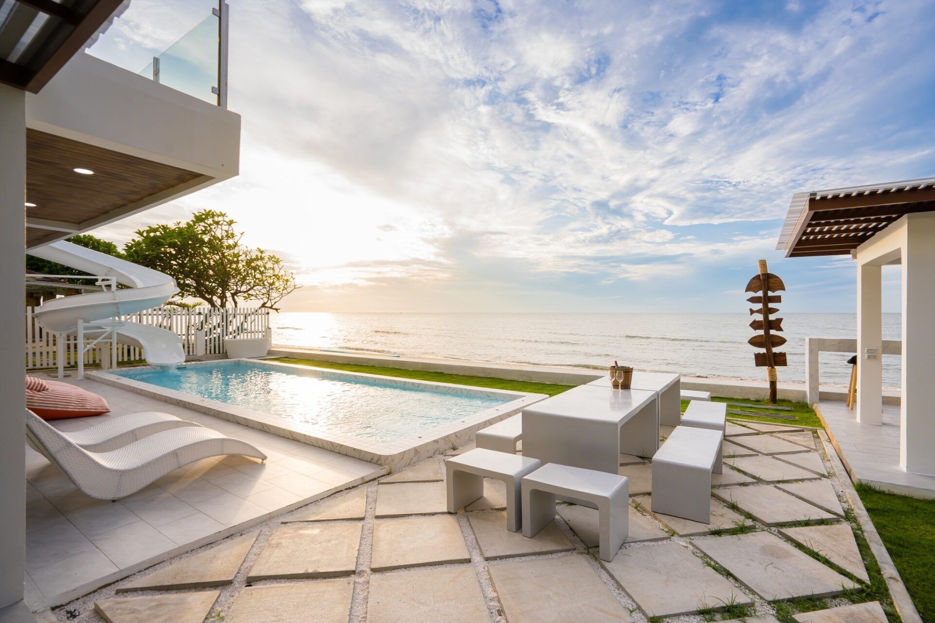 Sea Time V Pool Villa in Cha-Am features a private pool, slide, and outdoor dining with ocean views at sunset.