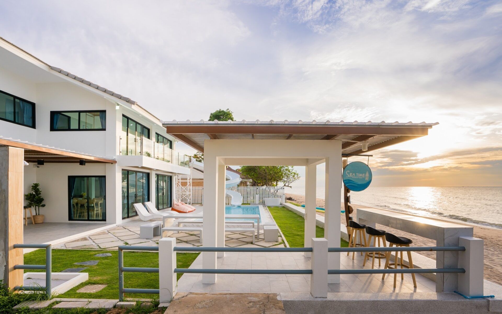 Beachfront view of Sea Time V Pool Villa in Cha-Am, Thailand. Modern villa with pool, beach access, and outdoor bar.