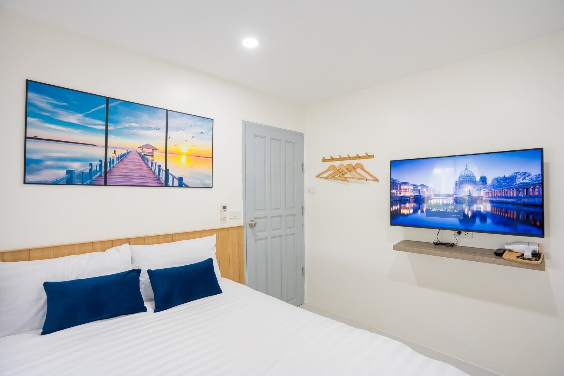 Modern bedroom with TV and artwork at Sea Time V Pool Villa, Cha-Am. Comfortable and stylish.