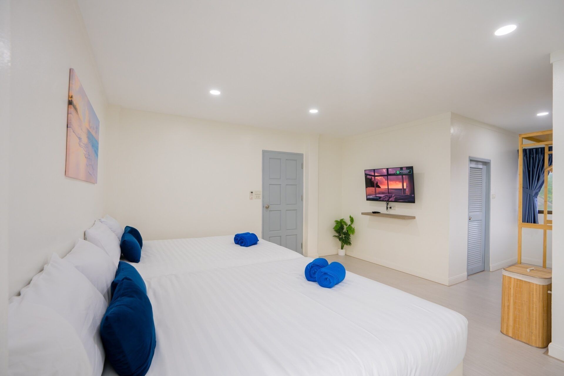 Bright bedroom with twin beds and blue towels at Sea Time V Pool Villa, Cha-Am, Thailand.