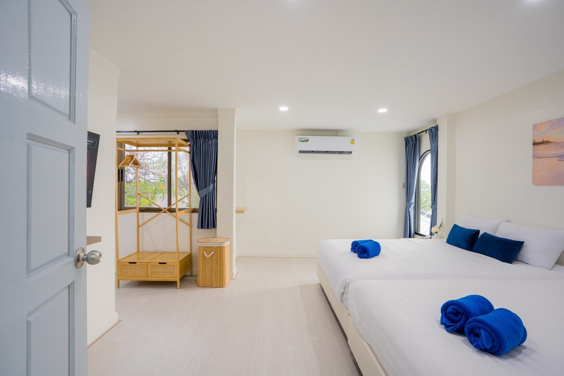 Bright bedroom with twin beds and blue accents at Sea Time V Pool Villa, Cha-Am, Thailand.