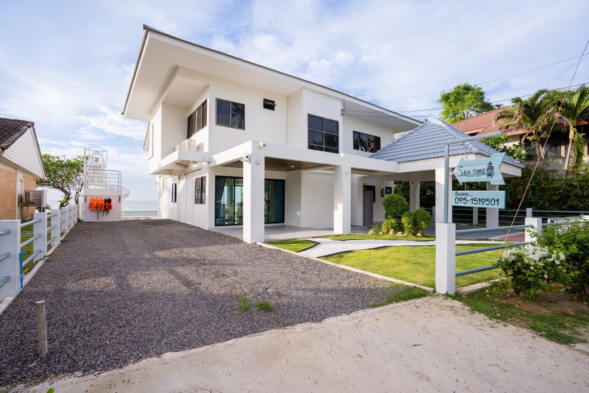Exterior view of Sea Time V Pool Villa in Cha-Am, Thailand. Shows the modern facade, driveway, and garden.