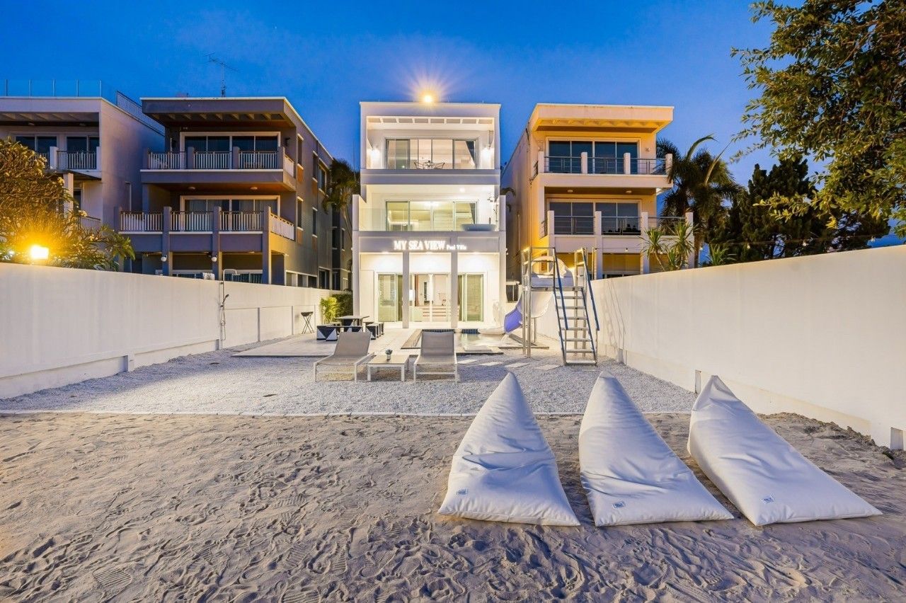 Exterior of Sea View IV Pool Villa, beachfront in North Pattaya. View of the villa, beach, and outdoor seating.