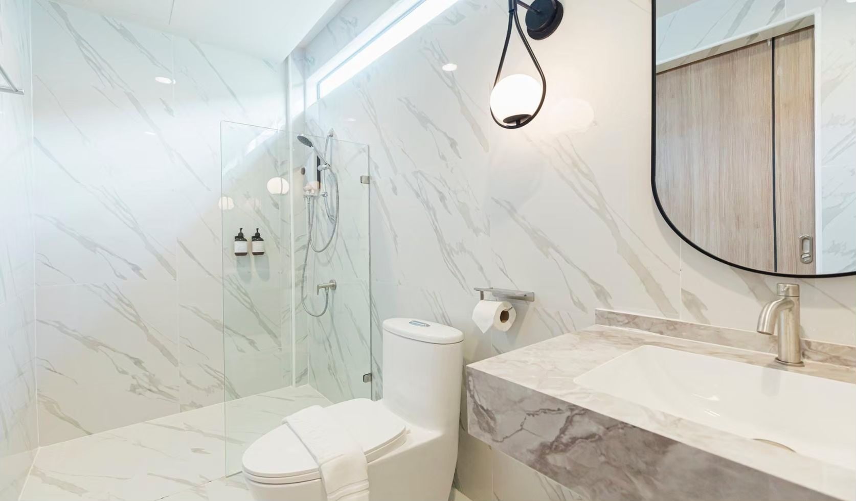 Modern bathroom with marble walls and glass shower at SHORE SEASON V POOL VILLA, Banglamung, Pattaya.