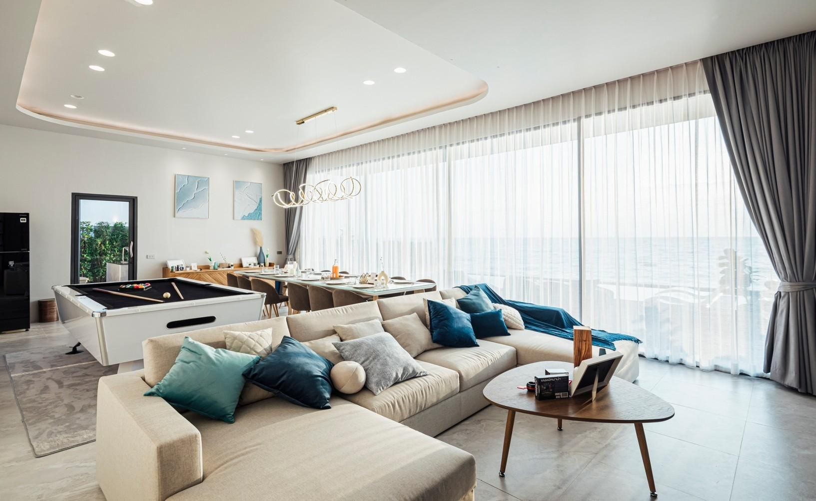 Bright living area with sectional sofa and pool table at SHORE SEASON V POOL VILLA, Banglamung, Pattaya.