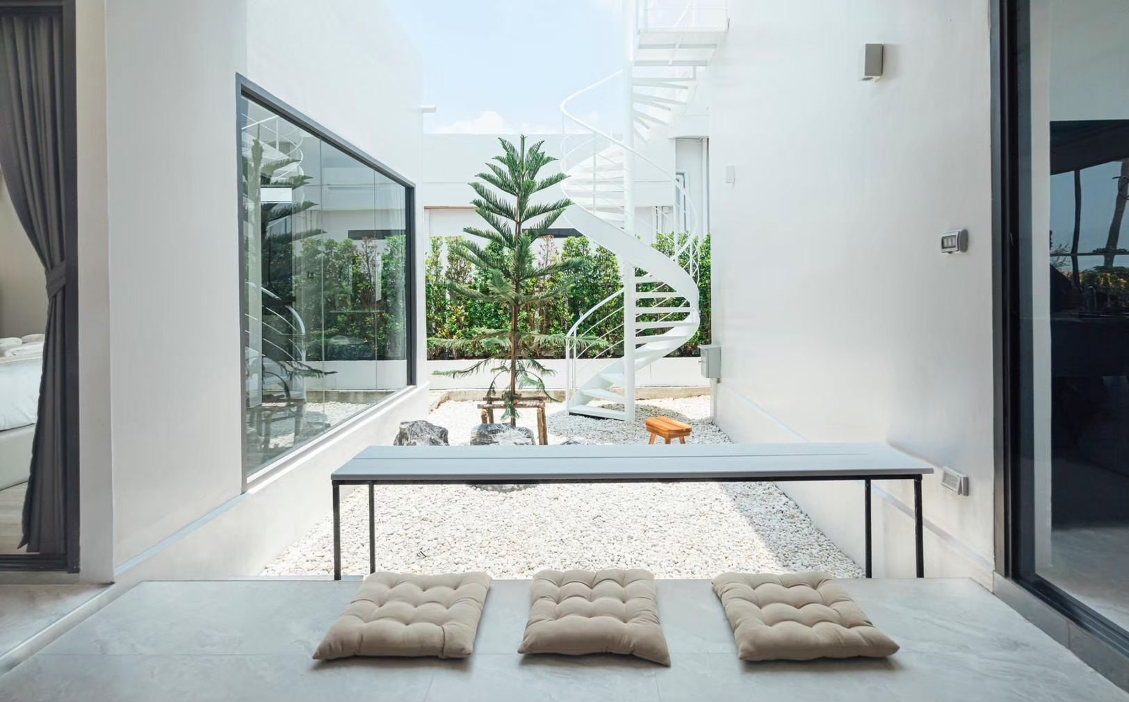Courtyard with spiral staircase at SHORE SEASON V Pool Villa, Banglamung, Pattaya. Features white gravel and seating cushions