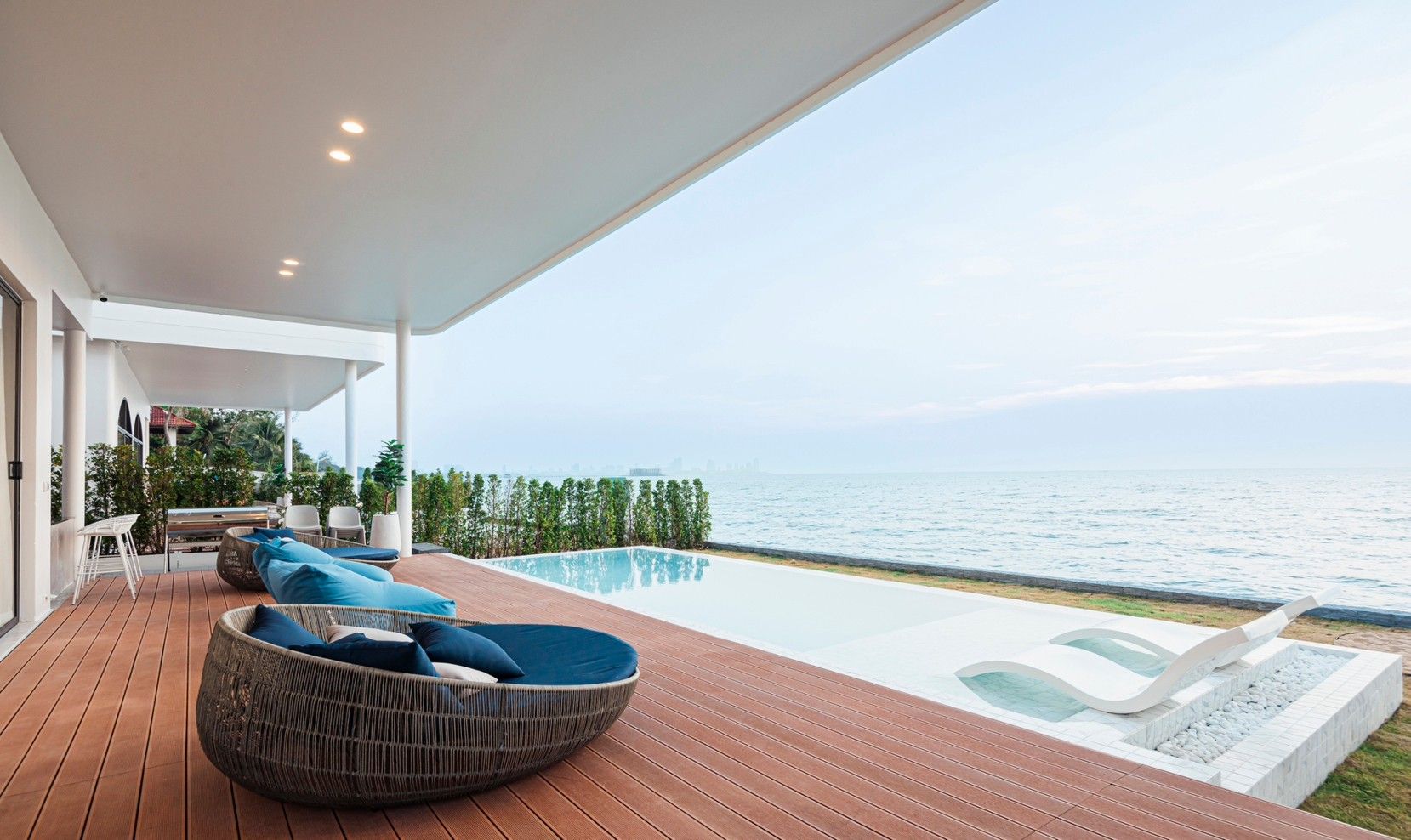 SHORE SEASON V pool villa in Pattaya. Oceanfront infinity pool and deck with lounge chairs overlooking the sea.