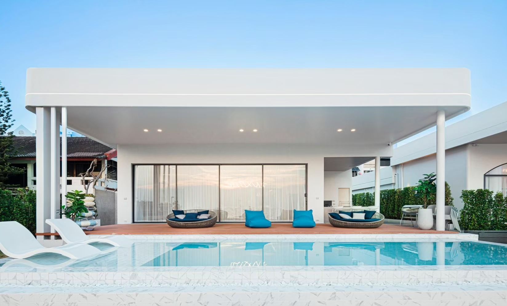 SHORE SEASON V Pool Villa in Banglamung, Pattaya. View of the pool with lounge chairs and outdoor seating area.