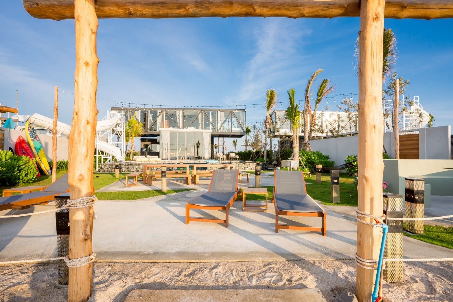 Beachfront lounge chairs at Spirit V Pool Villa, หาดปึกเตียน-ชะอำ. View of the villa and waterslide from the beach.