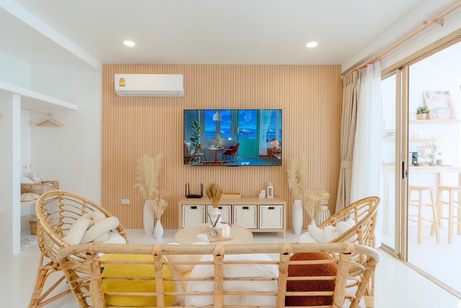 Story II Pool Villa Hua-Hin living room with rattan chairs, TV, and sliding glass doors to the patio.