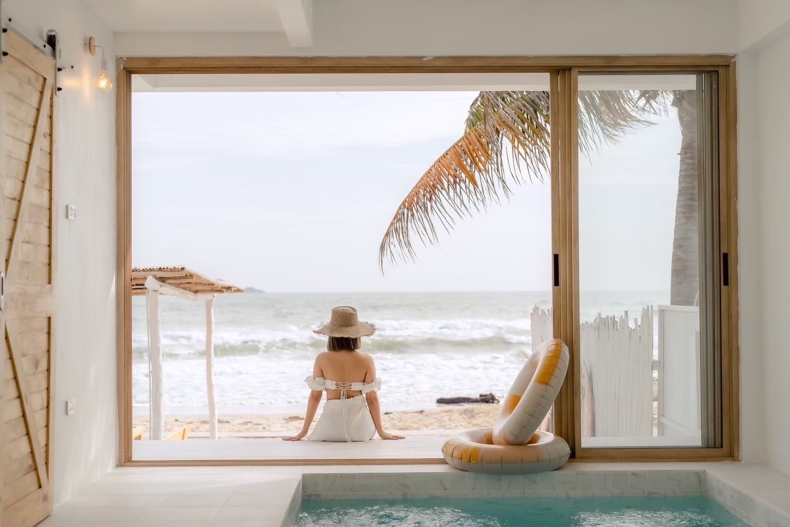 Woman relaxing by the pool with ocean view at Story II Pool Villa, เขาเต่า-หัวหิน. Beachfront luxury.