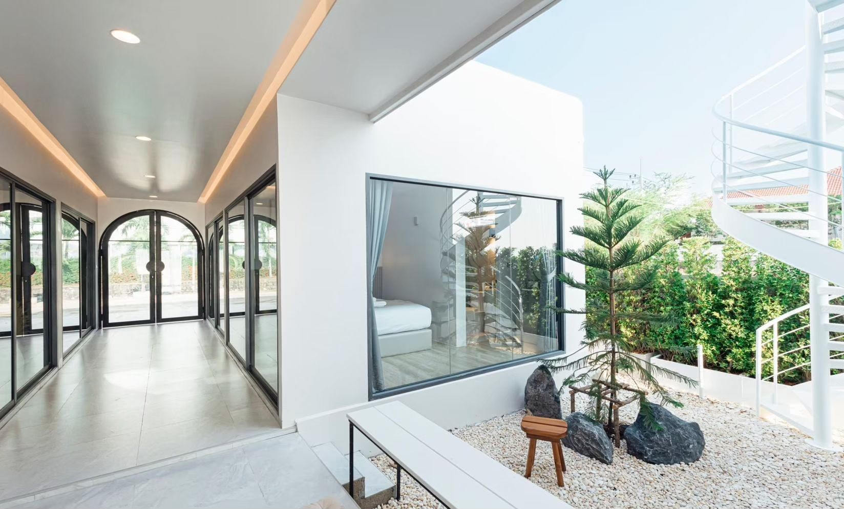 Exterior courtyard with spiral staircase at SUN SEASON V Pool Villa, Banglamung, Pattaya. View of bedroom through window.