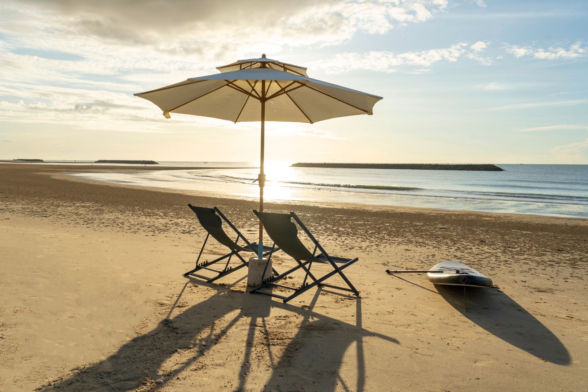 Beachfront lounge chairs and umbrella at Talay Haus X Pool Villa, หาดเจ้าสำราญ-ชะอำ เพชรบุรี. Relax on the beach near this po