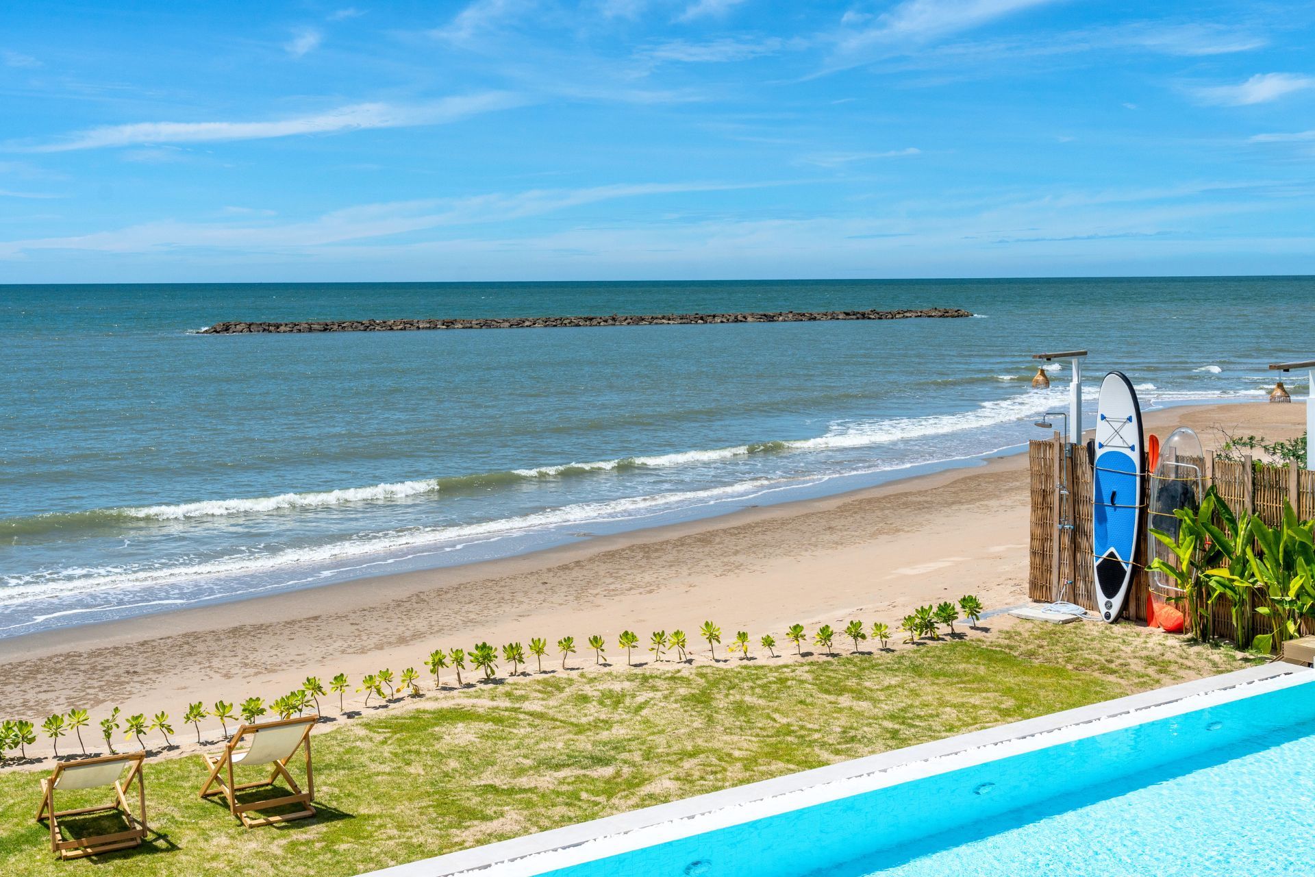 Beachfront view from the pool at Talay Haus X Pool Villa, หาดเจ้าสำราญ-ชะอำ เพชรบุรี. See the ocean from the pool deck.