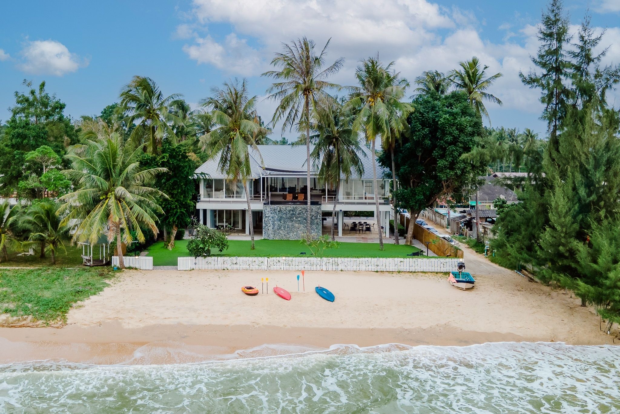 Aerial view of THE PINE V Pool Villa beachfront facade, with kayaks on the sand.