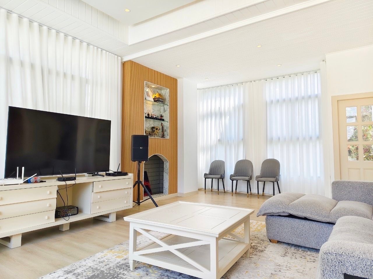 Living room at The Valley Khao Yai II pool villa. Features TV, karaoke setup, sofa, and chairs in Pak Chong, Thailand.