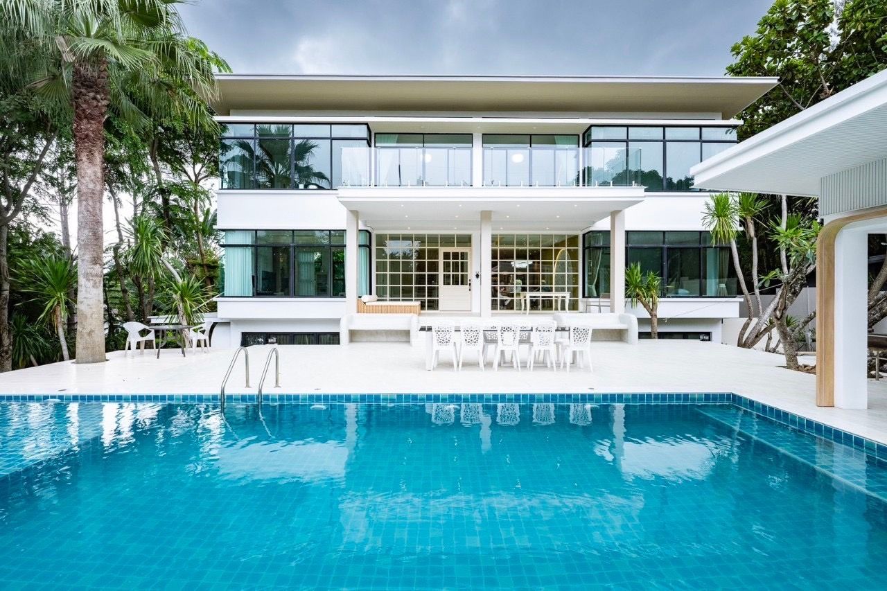 The Valley Khao Yai II pool villa facade reflecting in the blue tiled pool. Modern architecture in Khao Yai, Thailand.